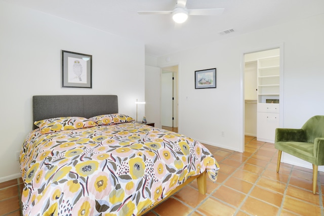 tiled bedroom with a walk in closet, a closet, and ceiling fan