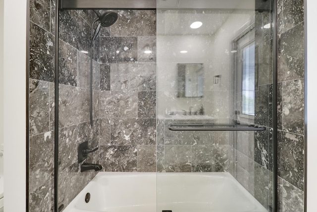 bathroom with bath / shower combo with glass door