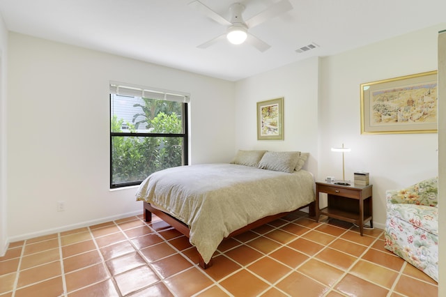 tiled bedroom featuring ceiling fan and multiple windows