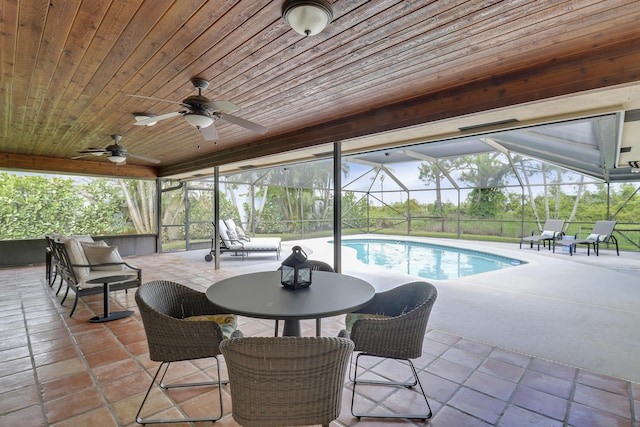 view of swimming pool with a patio area, ceiling fan, and glass enclosure