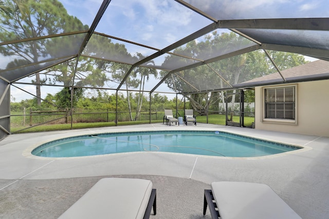 view of swimming pool featuring a patio area and glass enclosure