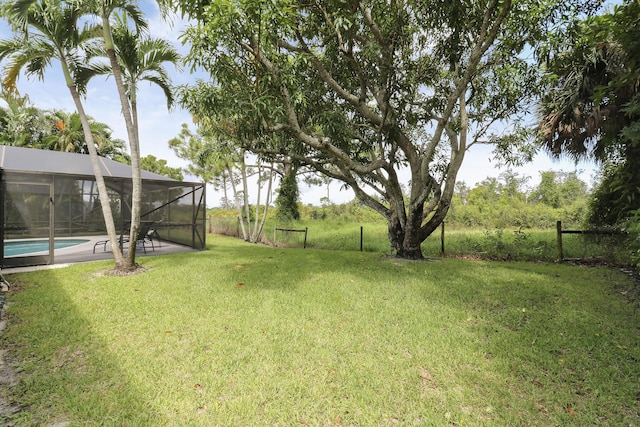 view of yard featuring a patio and glass enclosure