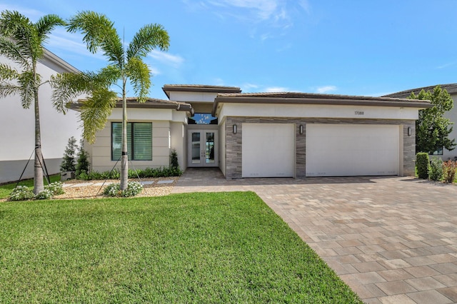 view of front facade with a front lawn, a garage, and french doors