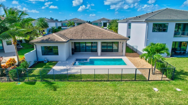 back of house featuring a fenced in pool, a lawn, and a patio