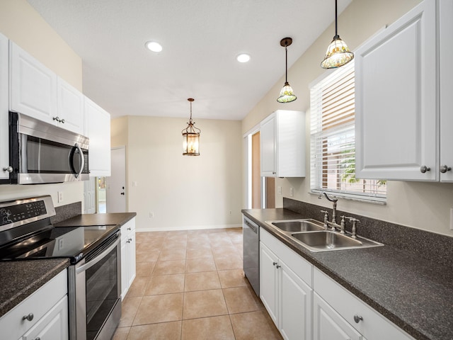 kitchen featuring stainless steel appliances, sink, light tile patterned flooring, white cabinetry, and decorative light fixtures