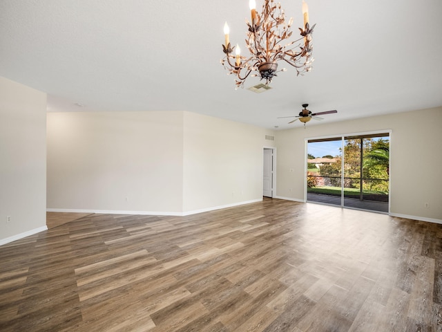 unfurnished room featuring hardwood / wood-style floors and ceiling fan with notable chandelier