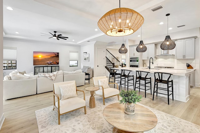 living room with ceiling fan and light hardwood / wood-style flooring