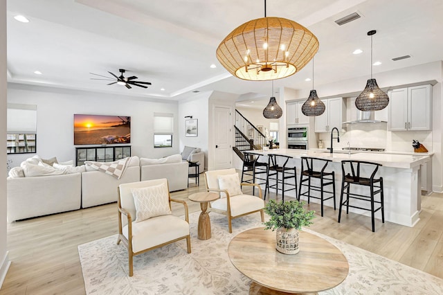 living room featuring ceiling fan and light wood-type flooring