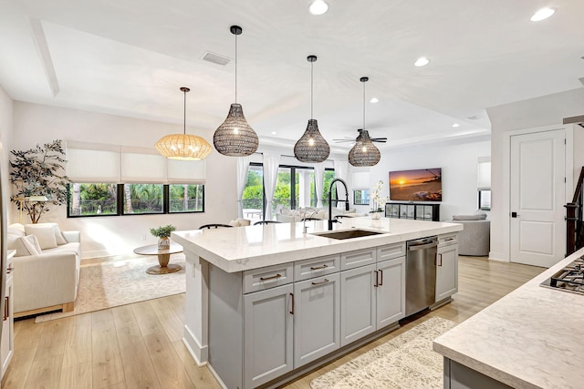 kitchen with dishwasher, sink, an island with sink, pendant lighting, and gray cabinets