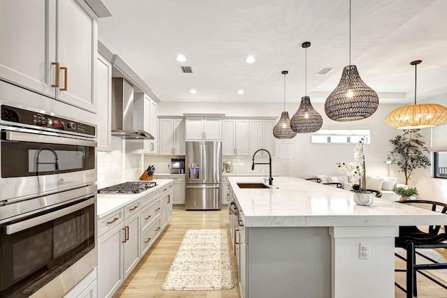 kitchen featuring a large island, hanging light fixtures, stainless steel appliances, and sink