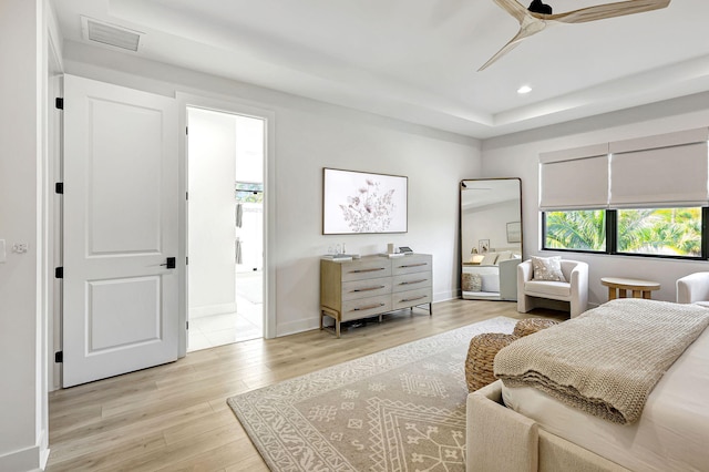 bedroom featuring ceiling fan, light hardwood / wood-style floors, and ensuite bath