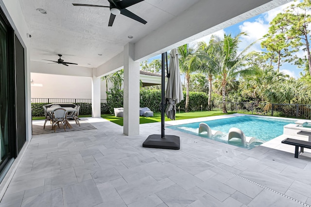 view of swimming pool with ceiling fan and a patio