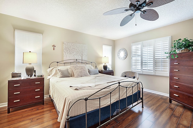 bedroom with ceiling fan, a textured ceiling, and dark hardwood / wood-style flooring