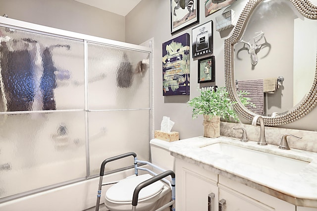 full bathroom with vanity, shower / bath combination with glass door, and toilet