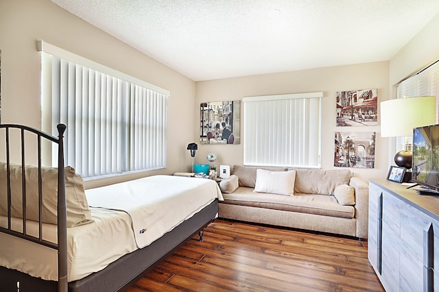 bedroom with a textured ceiling and dark hardwood / wood-style floors