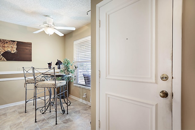 dining space featuring ceiling fan and a textured ceiling