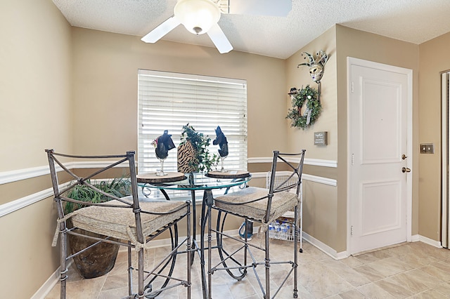 dining area with a textured ceiling and ceiling fan