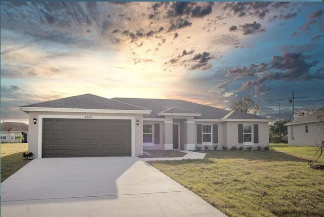 ranch-style home with a garage and a yard