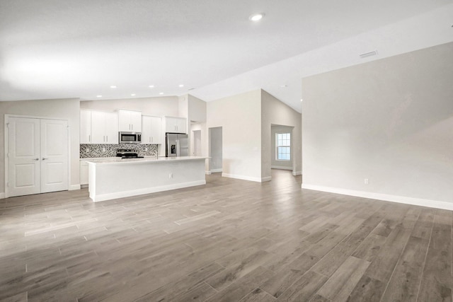 unfurnished living room featuring light hardwood / wood-style flooring and vaulted ceiling