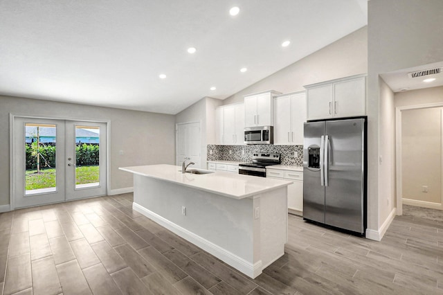 kitchen featuring sink, white cabinetry, a kitchen island with sink, stainless steel appliances, and french doors