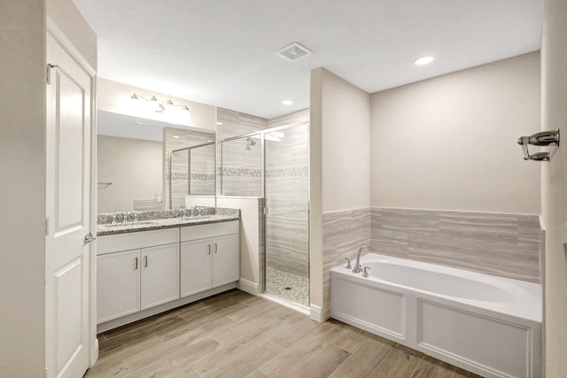 bathroom featuring vanity and plus walk in shower