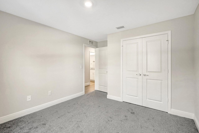 unfurnished bedroom featuring carpet and a closet