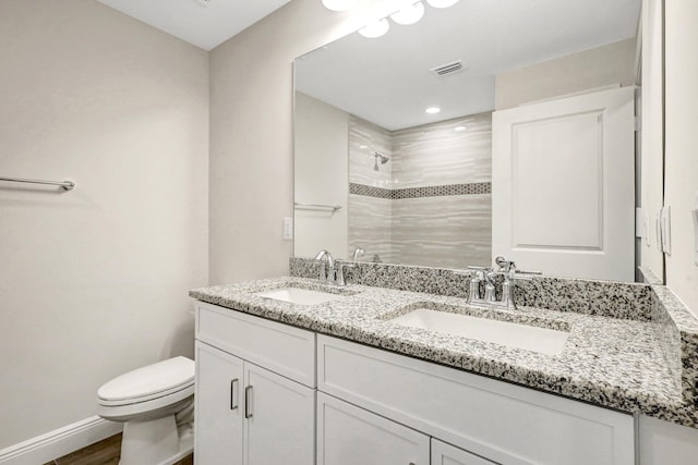 bathroom featuring toilet, wood-type flooring, vanity, and walk in shower