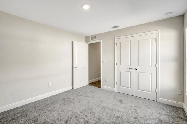 unfurnished bedroom with a closet and carpet flooring