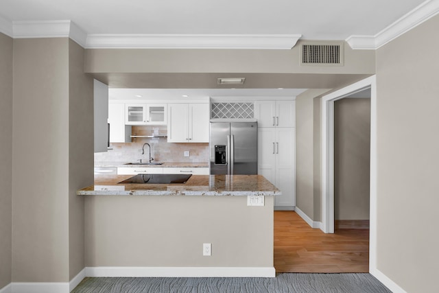 kitchen featuring light stone countertops, kitchen peninsula, stainless steel built in refrigerator, and white cabinets