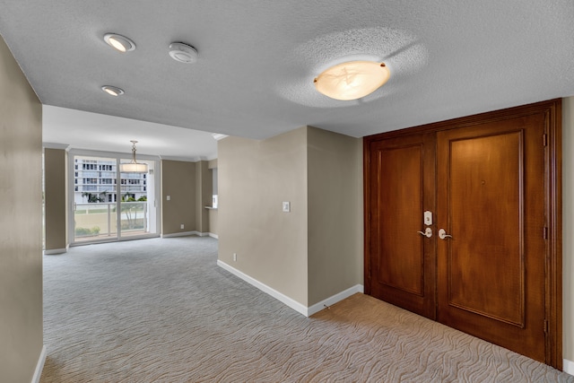 hallway with a textured ceiling and light colored carpet