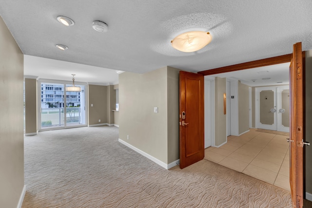 hall with light carpet and a textured ceiling