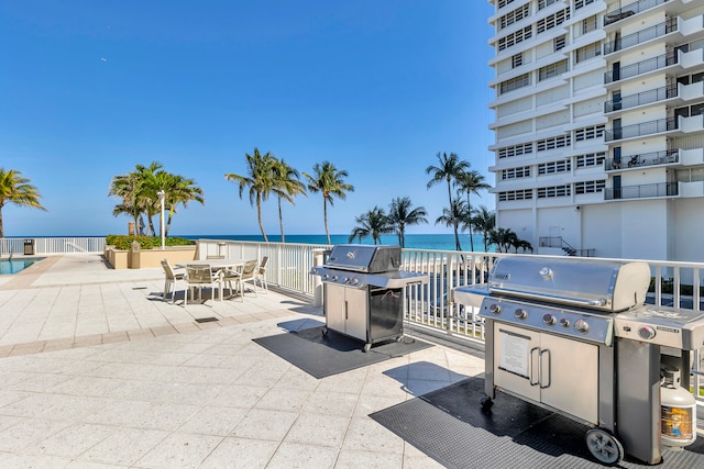 view of patio with a water view and area for grilling