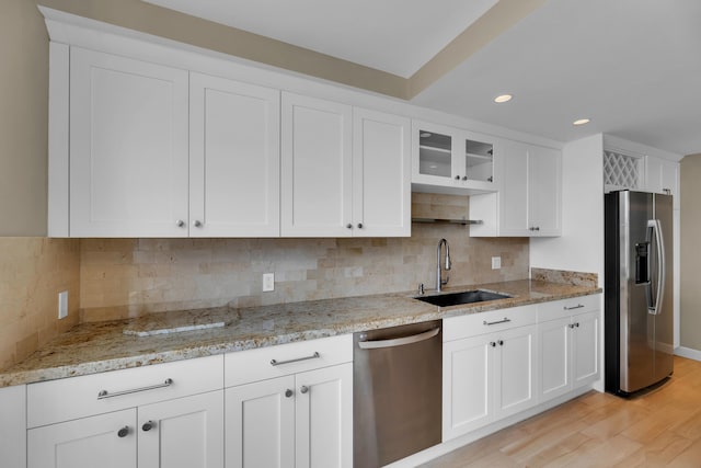 kitchen with white cabinetry, stainless steel appliances, sink, and light wood-type flooring