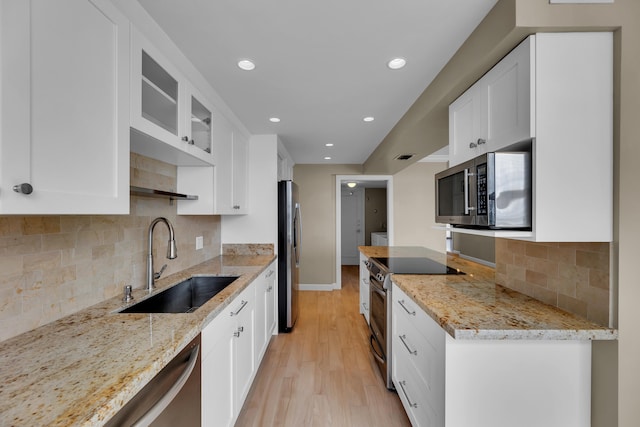 kitchen with white cabinetry, light hardwood / wood-style floors, stainless steel appliances, and sink