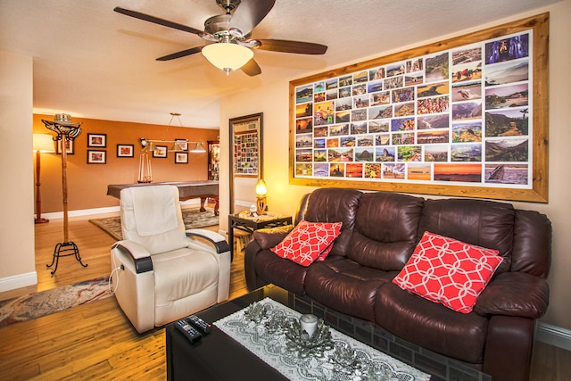 living room with a textured ceiling, hardwood / wood-style flooring, and ceiling fan