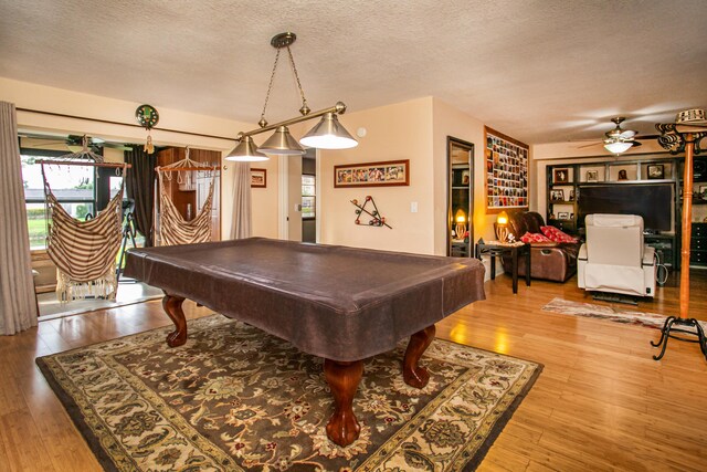 rec room featuring a textured ceiling, hardwood / wood-style flooring, billiards, and ceiling fan