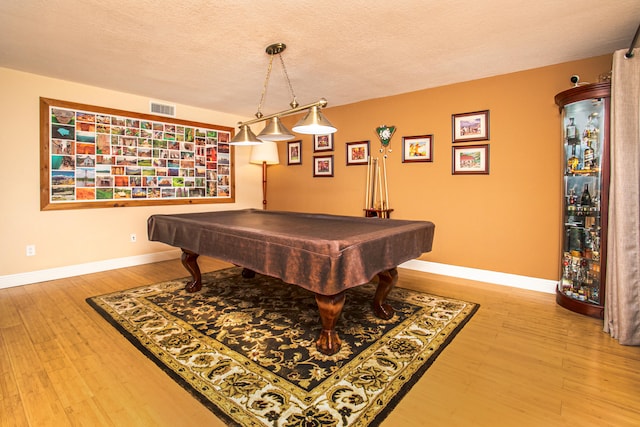 rec room with hardwood / wood-style floors, a textured ceiling, and billiards