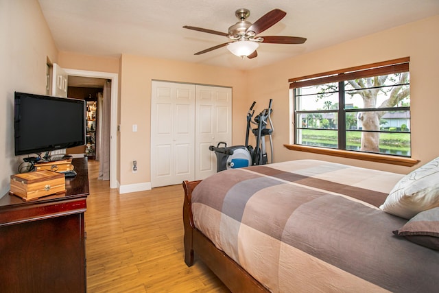 bedroom with a closet, light hardwood / wood-style floors, and ceiling fan