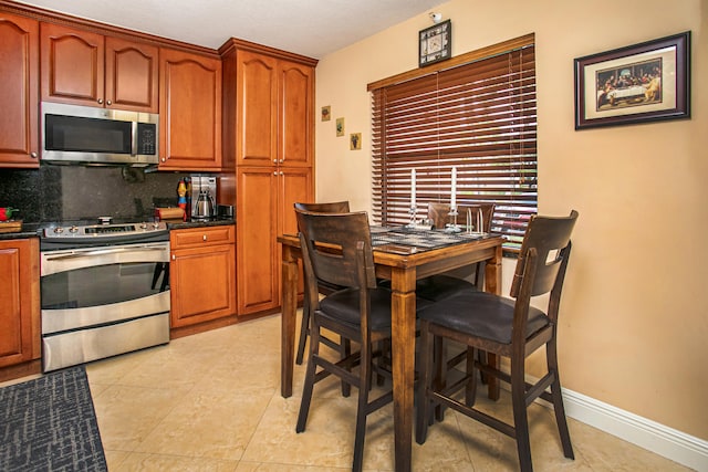 kitchen featuring tasteful backsplash, stainless steel appliances, and light tile patterned floors