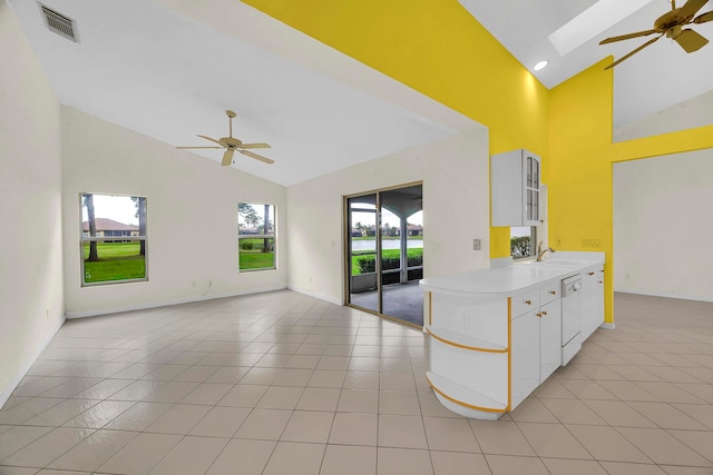 kitchen with a healthy amount of sunlight, white dishwasher, sink, and white cabinets