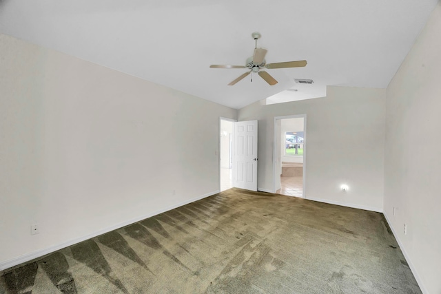 carpeted spare room featuring vaulted ceiling and ceiling fan