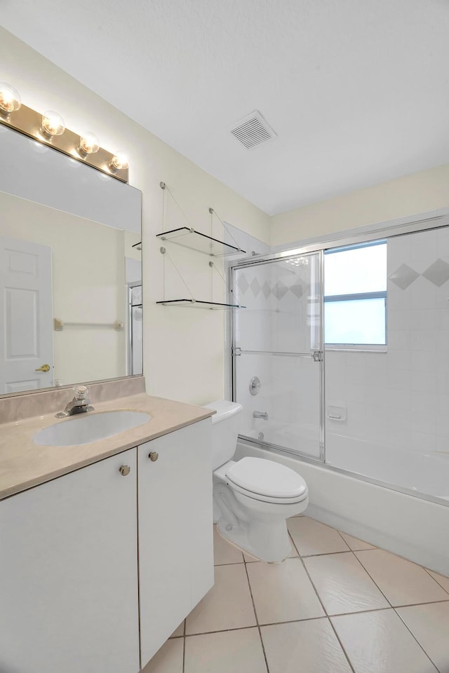 full bathroom with vanity, toilet, tile patterned floors, and bath / shower combo with glass door