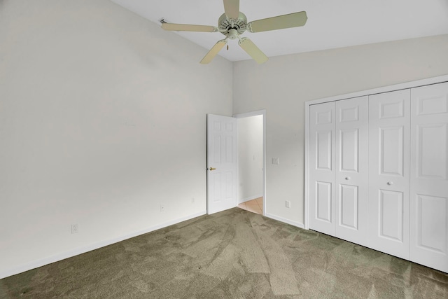 unfurnished bedroom featuring a closet, ceiling fan, high vaulted ceiling, and carpet flooring