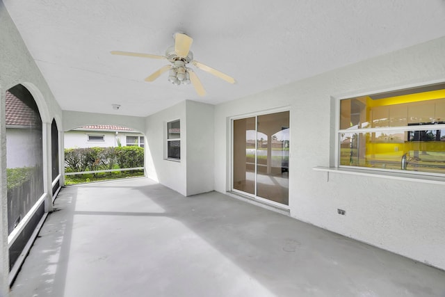 unfurnished sunroom with ceiling fan