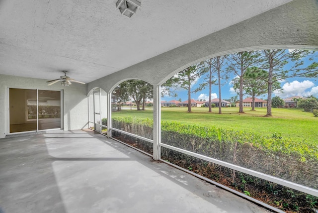 unfurnished sunroom with ceiling fan