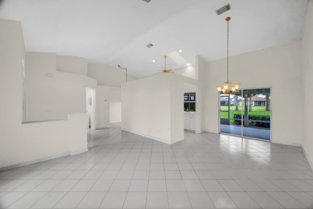 tiled empty room with high vaulted ceiling, a skylight, and ceiling fan with notable chandelier