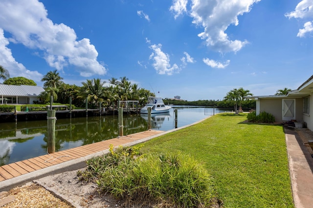 view of dock with a water view and a lawn