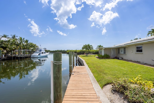 view of dock with a water view and a lawn