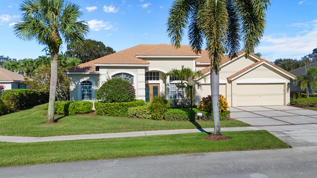 mediterranean / spanish-style house with a front yard and a garage