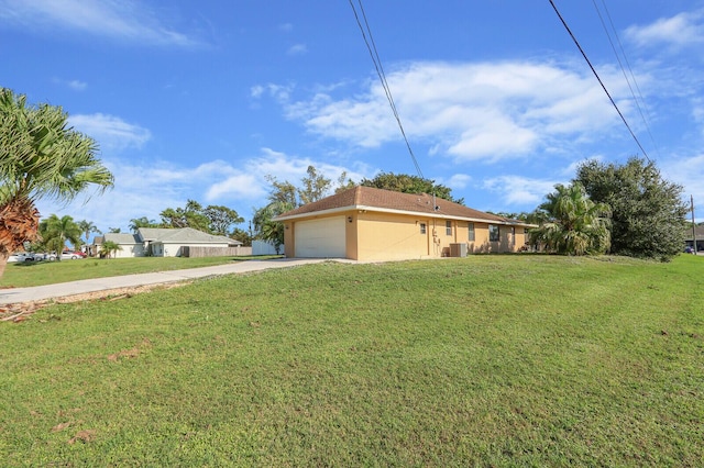 exterior space with an attached garage, a front lawn, central air condition unit, and driveway